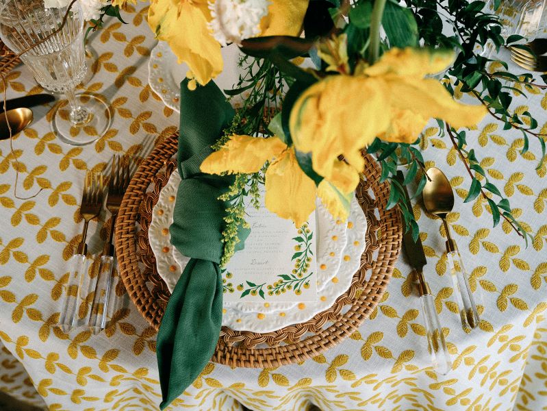 Elegant table setting with Santolina Golden tablecloth rental showcasing warm golden botanical pattern against neutral background
