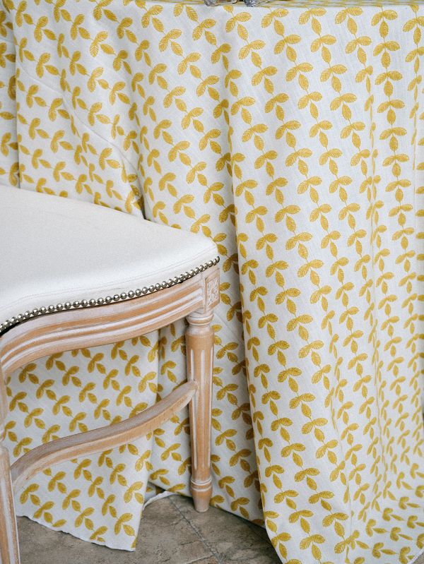 Detail shot of Santolina Golden tablecloth highlighting embroidered floral motifs inspired by Mediterranean Santolina flowers