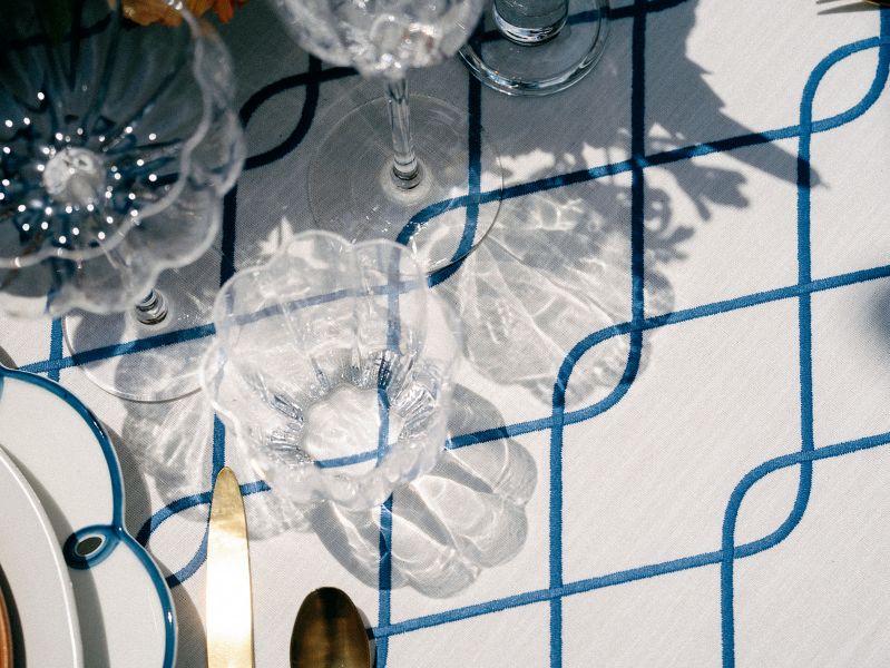 Rica Cobalt linen tablecloth rental showing rich cobalt blue hue and Mediterranean-inspired lattice embroidery pattern