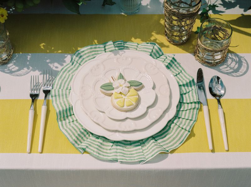 Close-up view of Vintage Stripe Zest tablecloth showing vibrant citrus striped pattern and sun-kissed golden Mediterranean colors