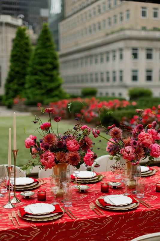 Gold-rimmed place setting on red metallic linen